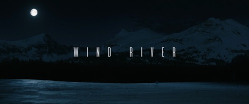 Movie Title image" The words "Wind River" are in teh middle of a rectangular poster, againt background of showy ground under a dark blue night sky